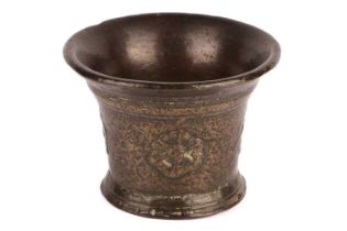 An early 17th century Continental bronze mortar, with repeating embossed wheel pattern, 10 cm high x