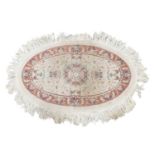 An ivory ground oval Tabriz rug with a central boss with a floral design within a fruiting vine bord