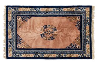 A salmon ground Chinese 'Pekking' carpet with central floral boss within blue and oatmeal borders, 2