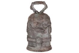 An archaistic Chinese bronze bell with a rustic loop handle the domed body with raised flowering ten