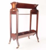 An Edwardian inlaid mahogany three-shelved book trough supported on splayed feet with brass cap cast