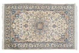 An ivory ground Nain rug with formal bookcover design, within palmette borders. 191 cm x 121 cm A pr