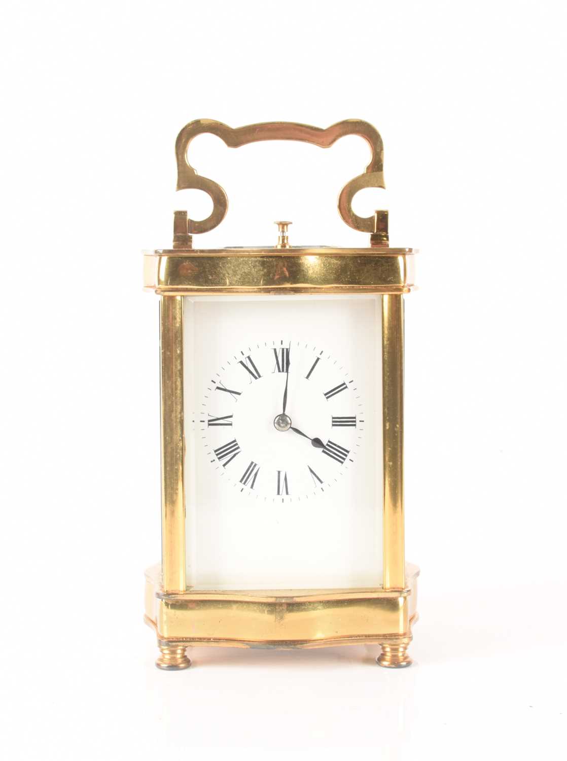 A French-style brass carriage clock with a serpentine corniche, repeating action and chiming on a go