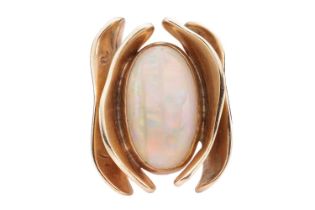 An opal dress ring of stylised design, featuring a bezel set precious opal, measuring approximately 
