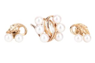 A Mikimoto pearl ring and earrings; the ring of stylised foliate design and set obliquely with six c
