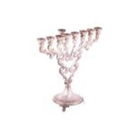 A Hanukkah menorah, a candelabrum with nine branches, in scrolled design, supported on three bracket