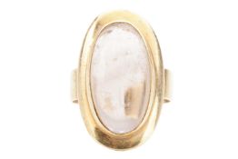 A smoky quartz cabochon dress ring, featuring an elongated oval smokey quartz of 2.3 x 1.1 cm, in a 