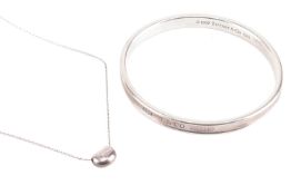 Tiffany &amp; Co. - an 1873 closed bangle and an Elsa Peretti bean charm on chain; the bangle struck