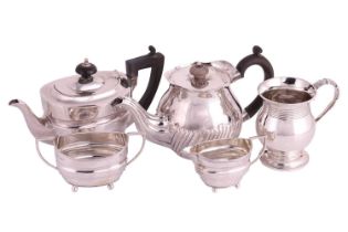 An early 20th-century three-piece silver tea set, the teapot with a wooden handle and finial-topped 