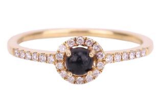 A Whitby jet and diamond halo ring in 18ct yellow gold, consisting of a round jet cabochon within