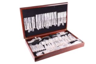 A group of mixed silver plated flatware in oak canteen cabinet.