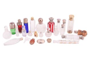 A collection of cut glass scent bottles, many with silver mounts, one featuring an enamel portrait