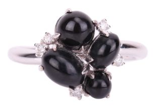 A Whitby jet cabochon cluster ring in 18ct white gold, comprising four oval jet cabochons in various