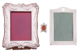 A collection of three silver photo frames; including an Edwardian silver photo frame with bow and