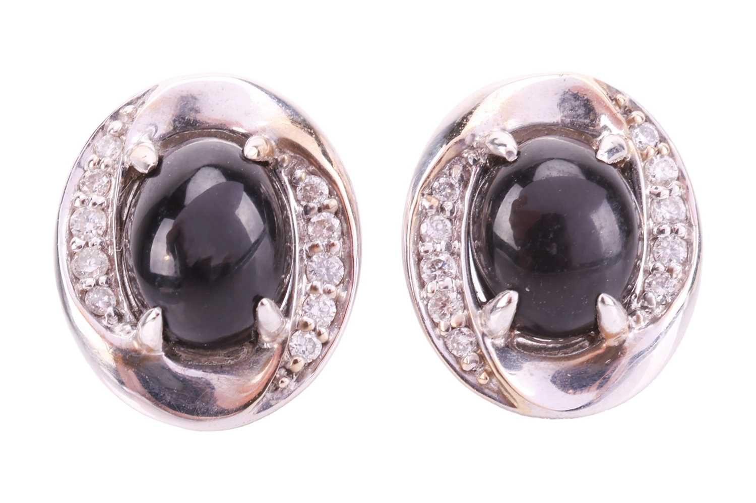 A pair of Whitby jet and diamond stud earrings in 18ct white gold, each containing an oval jet caboc