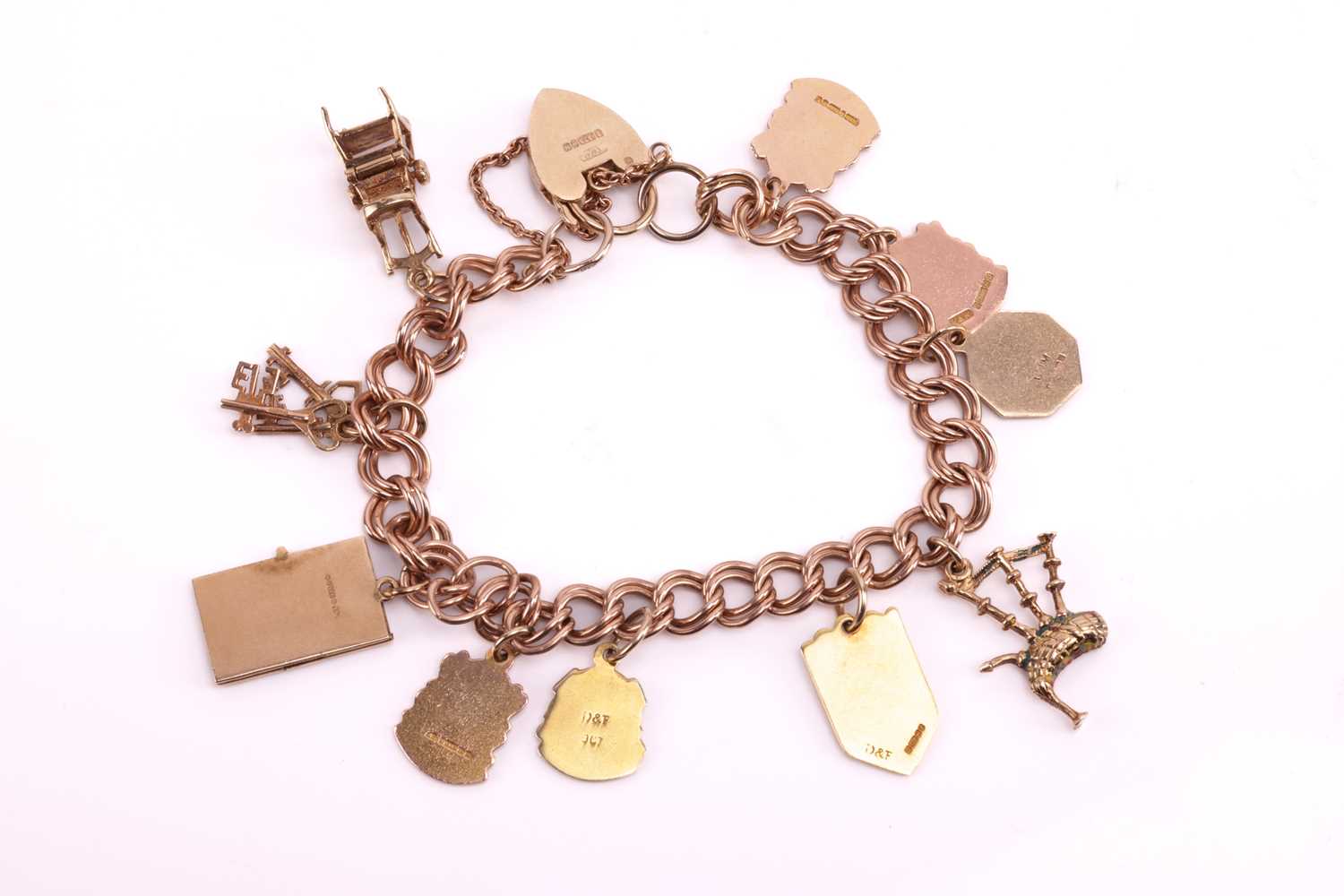 A 9ct gold charm bracelet featuring ten charms including a highchair, a set of three keys, a hinged  - Image 2 of 3