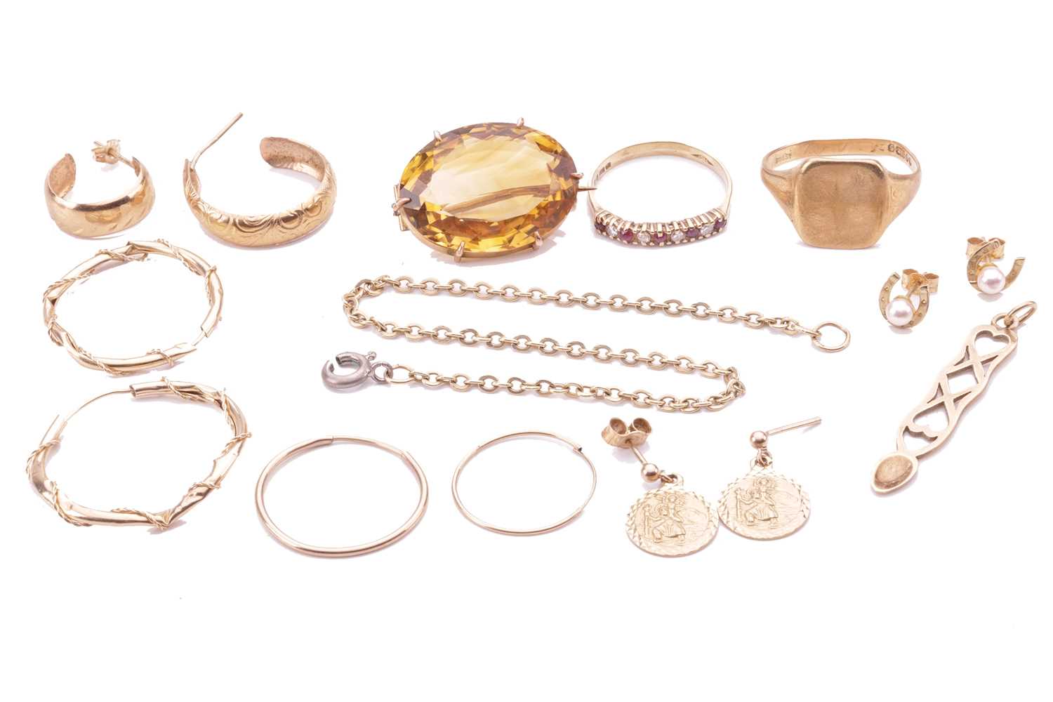 A collection of jewellery items comprising an oval citrine brooch in a yellow metal setting tested a