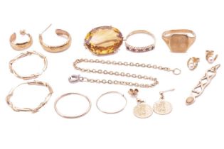 A collection of jewellery items comprising an oval citrine brooch in a yellow metal setting tested