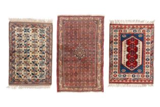 A small ivory ground Kazak rug with a field of holly leaves, within a serpent and baton border,