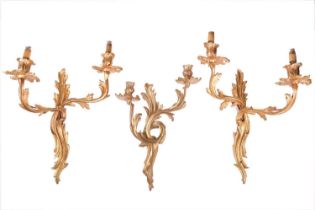 A pair of Louis XV-style ormolu effect double sconce wall lights with foliate scroll arms and drip