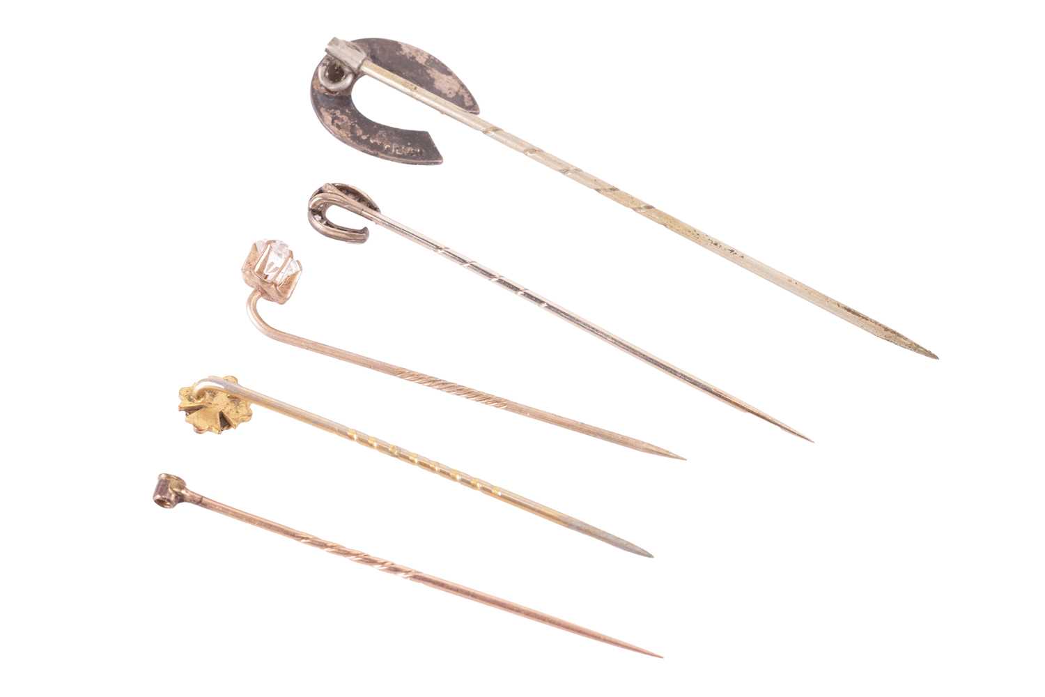 A collection of five stick pins. To include a rose cut diamond horseshoe stick pin testing at 9ct go - Image 2 of 4