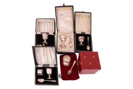 Two silver Christening egg cups and spoons in fitted cases, one with an associated hallmarked spoon,