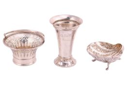 An Indian white metal shell-shaped dish, profusely decorated with animals, trees and dwellings, on t