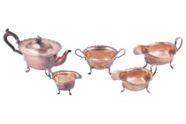 A three-piece silver bachelor teaset, oval with everted borders the cream jug and sugar bowl with le