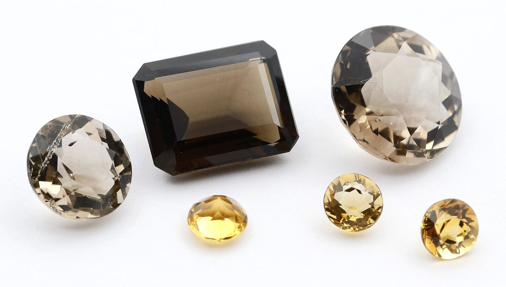 Lot aus je 3 Citrinen und Rauchquarzen, zus. ca. 24,7 ct.