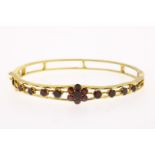 Yellow gold stiff bracelet set with garnets, fitted with a box clasp with security cord, diameter