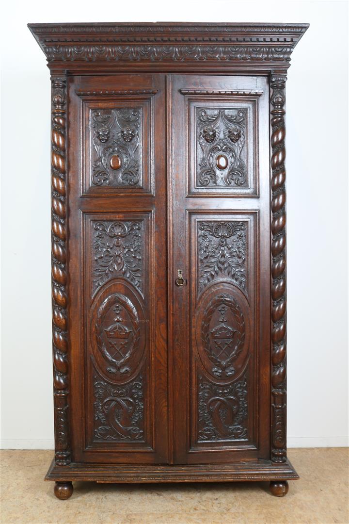 Oak two-door cupboard with 4 carved panels of garlands, putto, shell motifs and crown, flanked by