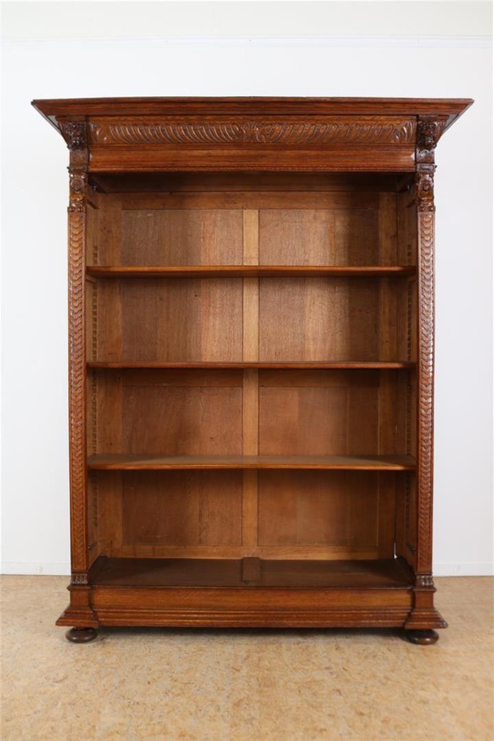 Oak Renaissance style open bookcase with carved "grunts" in the hood and carved lion masks and