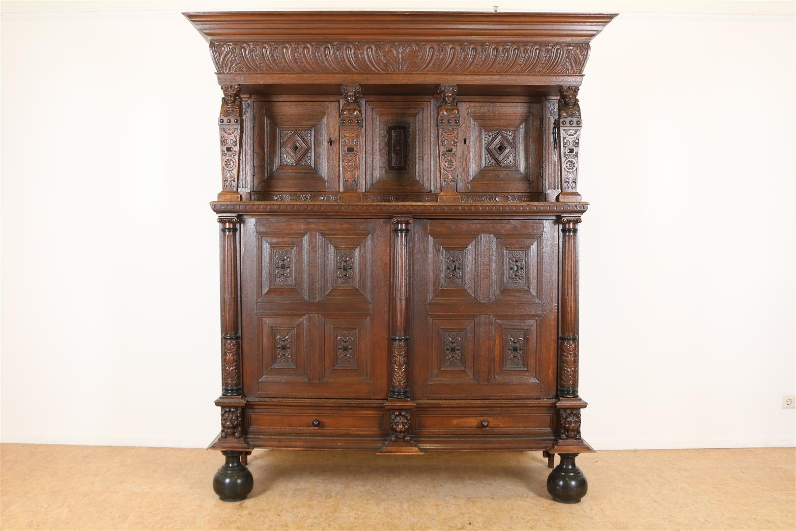 Oak Renaissance cabinet with richly carved crest, recessed elevation with 3 panel doors resting on 4