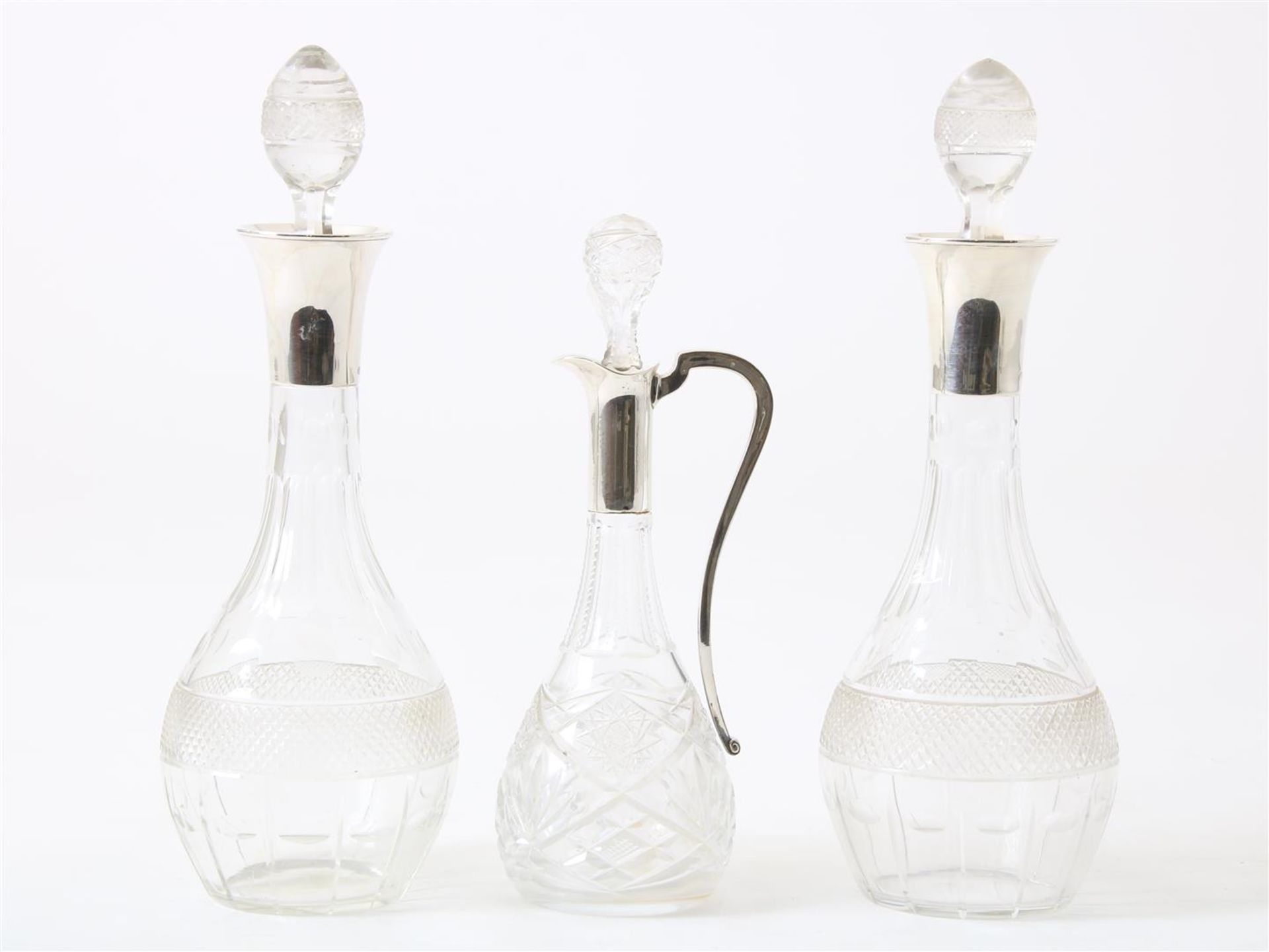 Set of crystal decanters with silver frames, and a crystal decanter with silver handle and frame