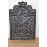 Cast iron fireback with scallop shell flanked by dolphins and depicting a kneeling woman with 3