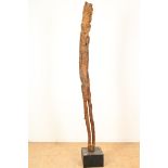 Wooden ancestor statue figure as an elongated male person, probably Dayak Borneo on a pedestal,