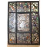 Stained glass window with decor of grape vines, playing cards and guitar, text: offered by