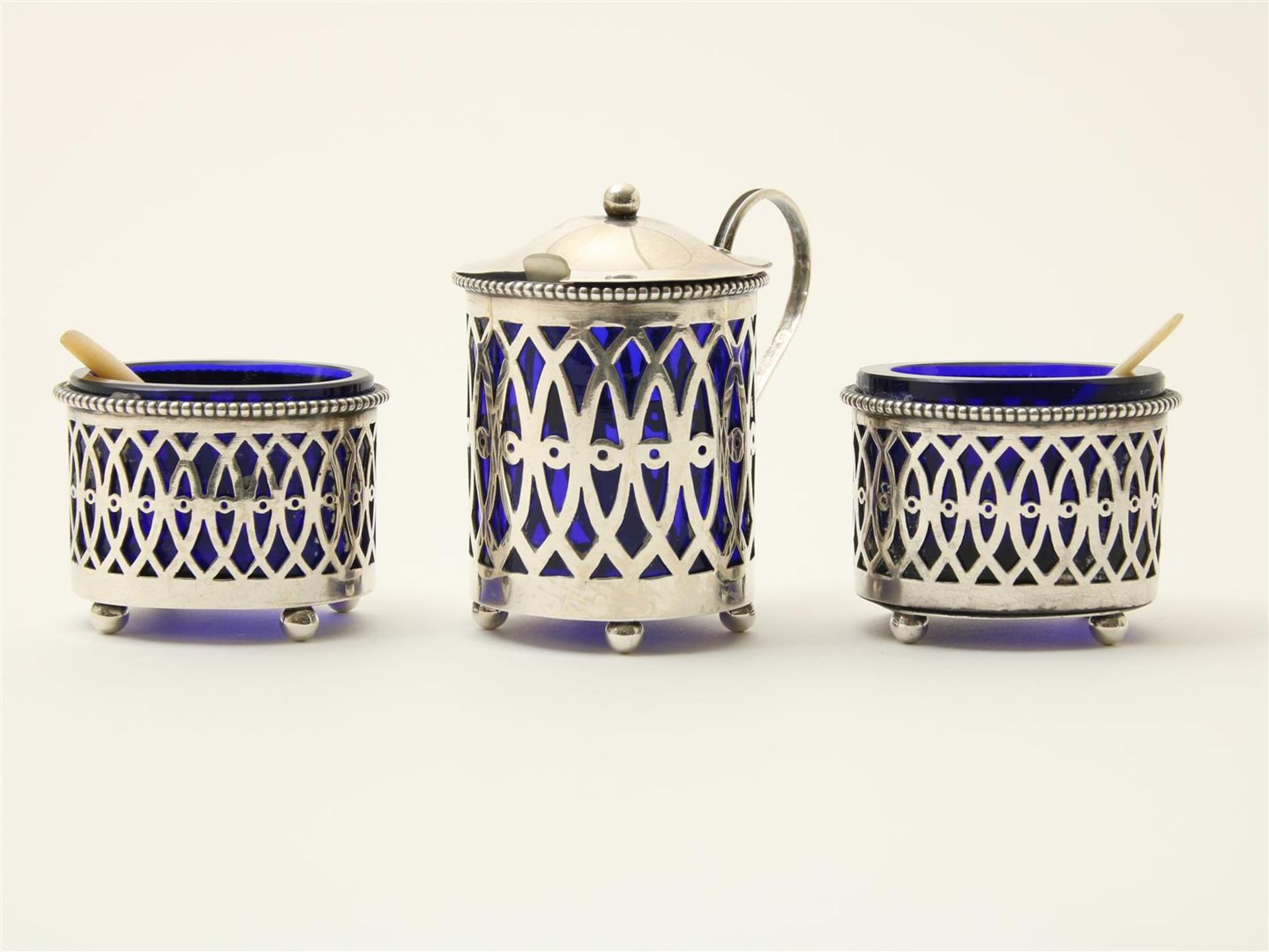 Openwork silver mustardpot and two salt cellars