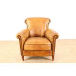 Club armchair upholstered in brown leather, resting on wooden legs.