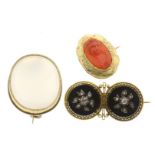 A lot with 3 gold brooches, including one set with carved red coral with a woman in profile; black