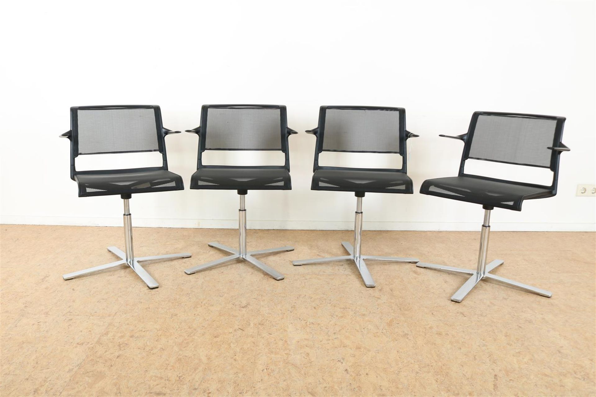 Series of 4 armchairs with black polyester mesh upholstered on chrome-plated swivel base, label