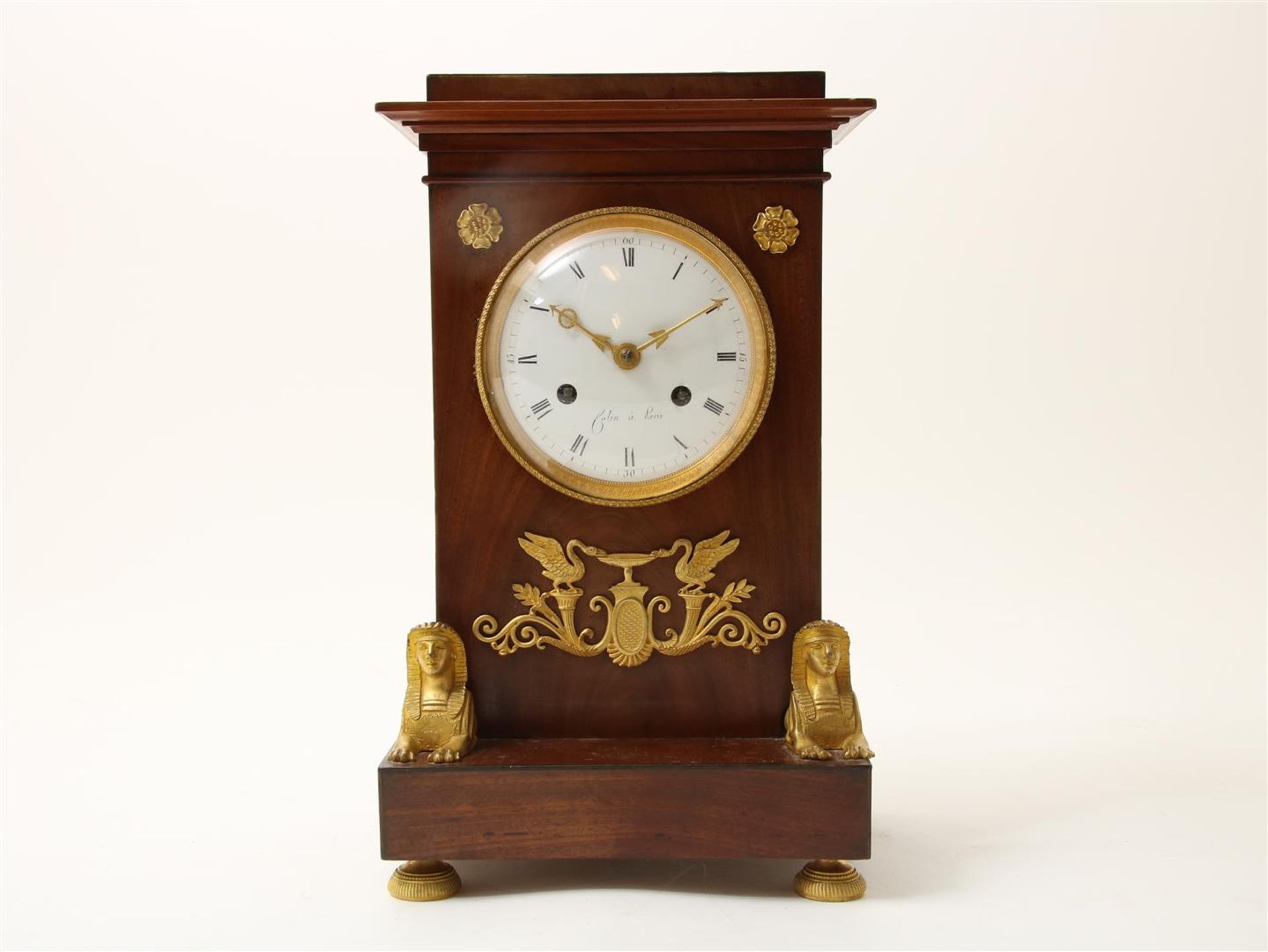 Empire mantel clock in mahogany case with white enamel dial with Roman numerals and fire-gilt Sphinx