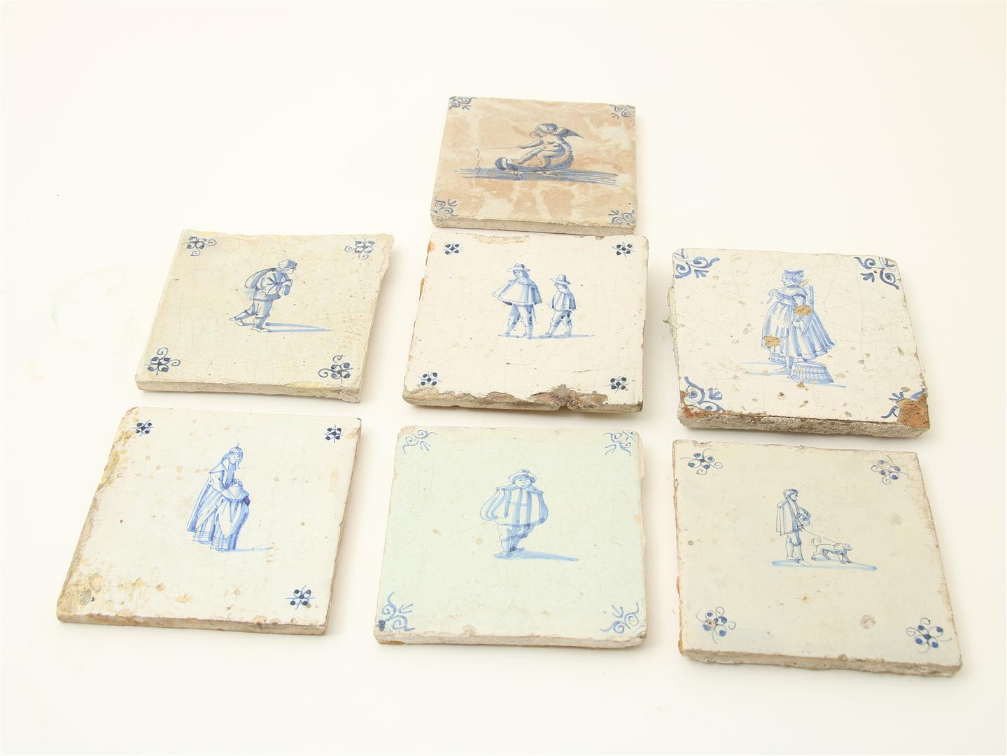 A lot of 7 various 17th century earthenware tiles decorated with figures (various qualities) (7x)