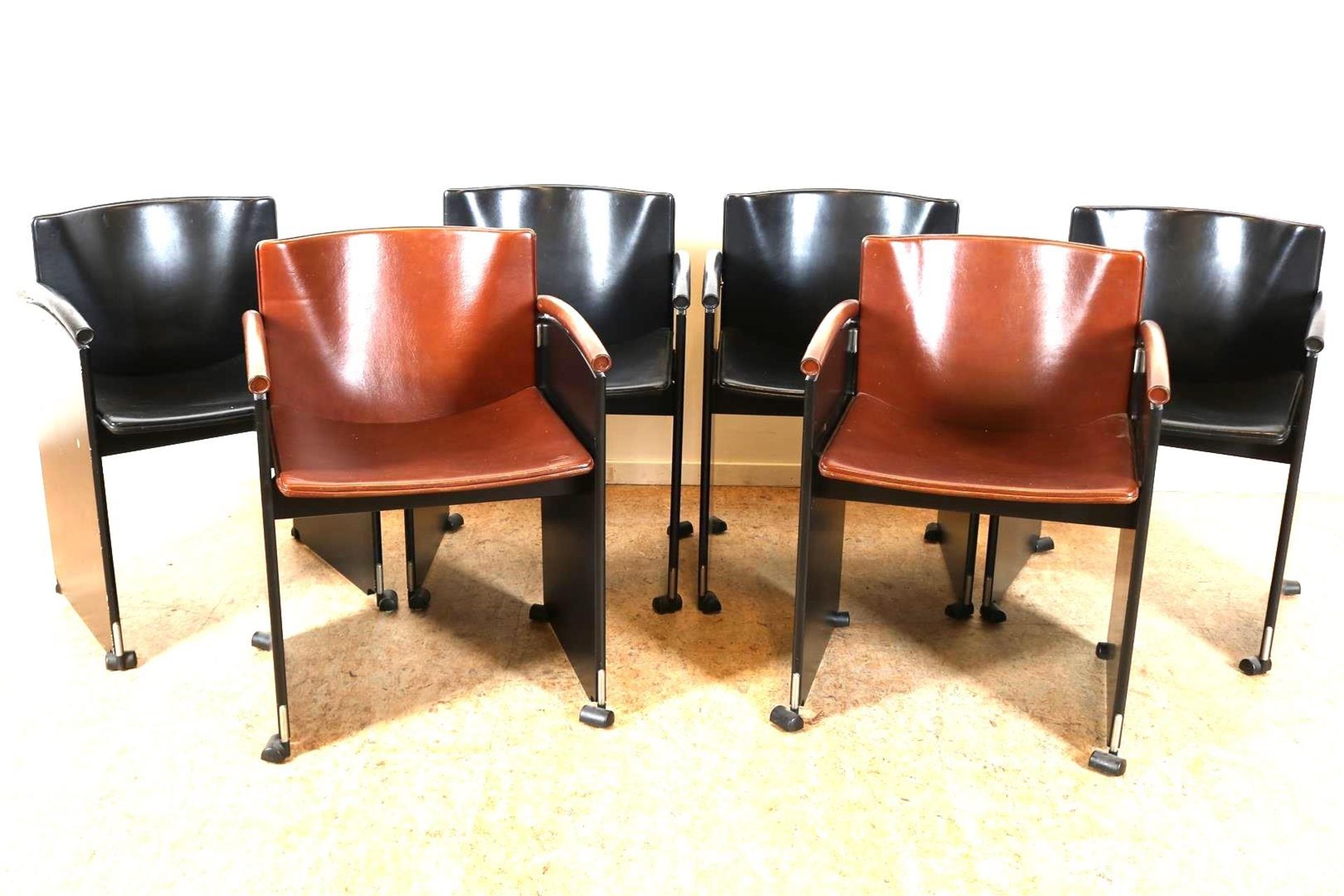 Series of 6 designer armchairs with leather upholstery, (2x brown and 4x black) on wheels,