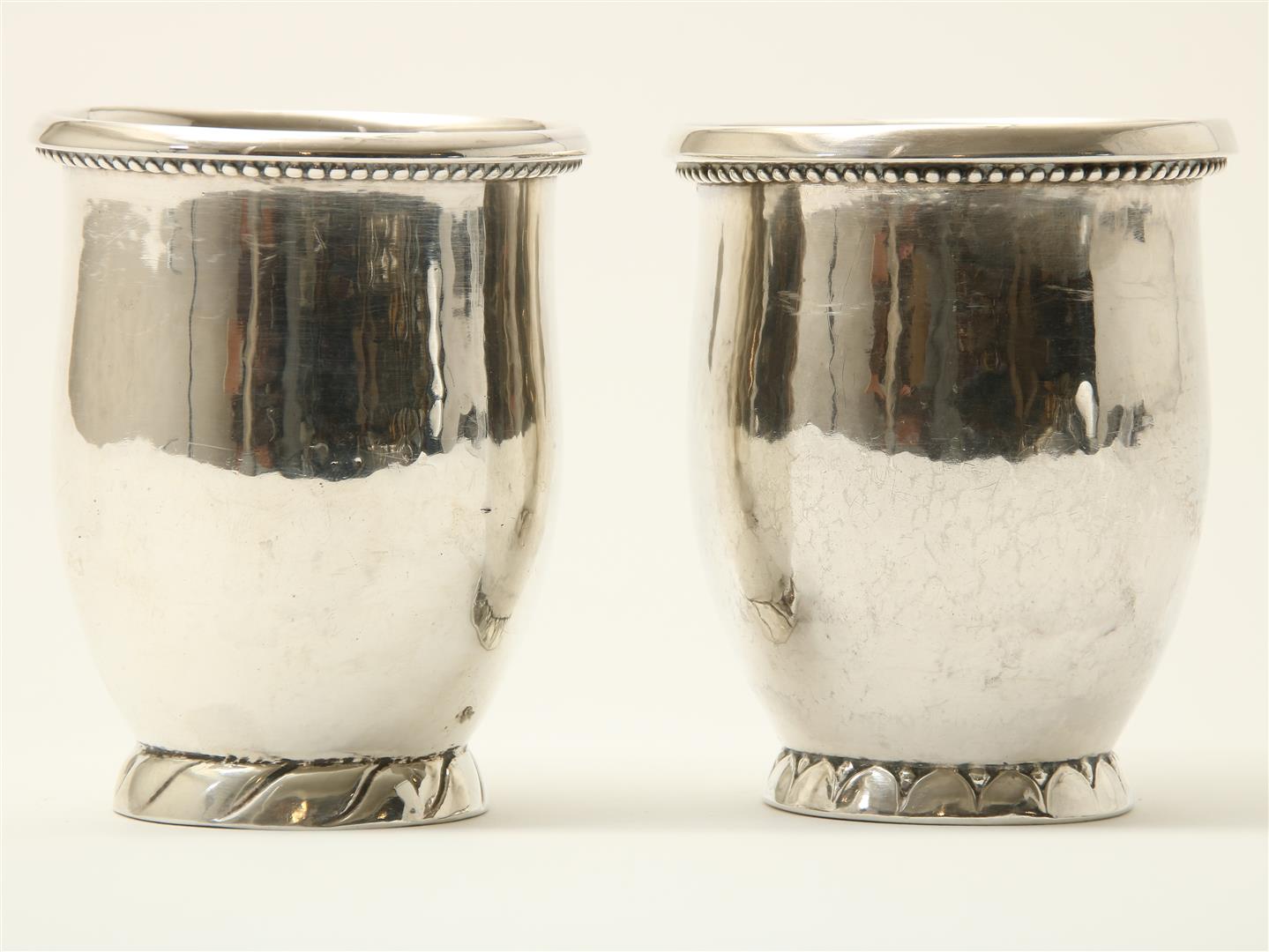 Two silver cups with hammered decor and trimmed with pearl rim, grade 830/000, maker's mark: Georg