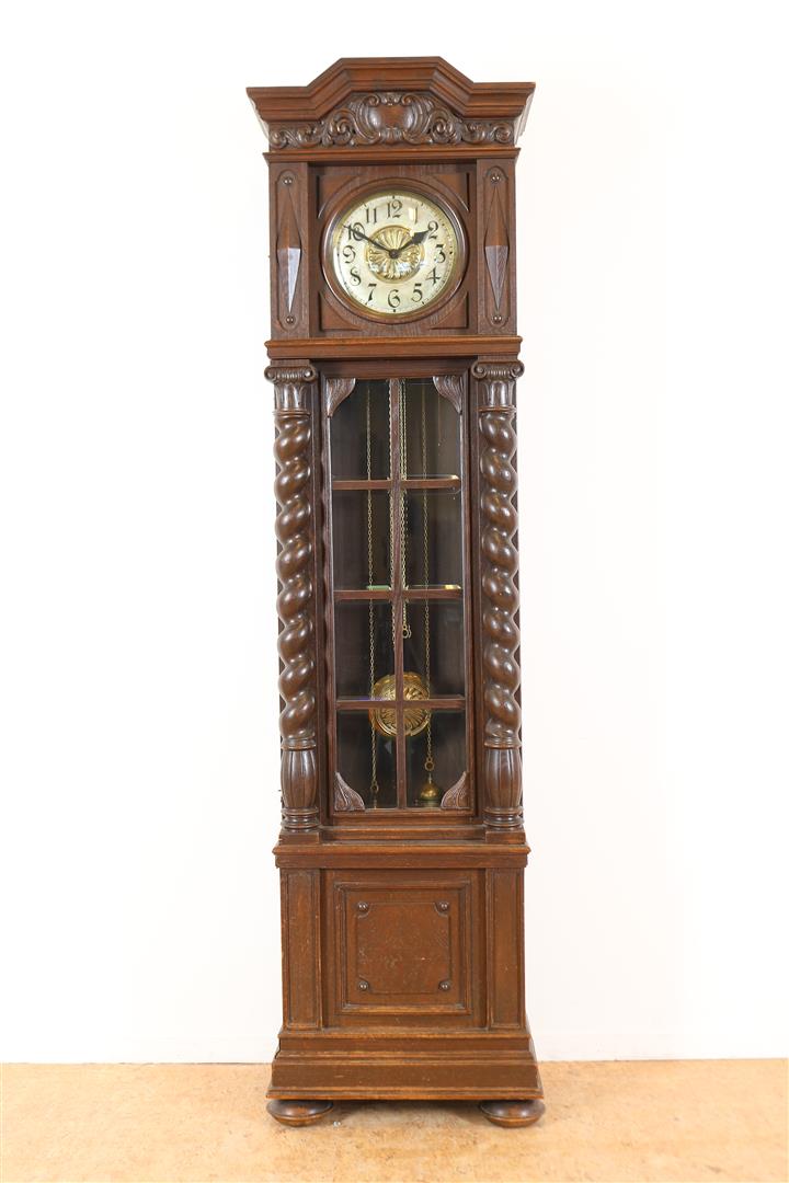Standing watch with partly copper dial in oak case with carved C-volutes in crest and flanked by
