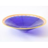 Blue glass bowl with red stripes and yellow edge, signed Kjell Engman for Kosta Boda, 8 x 34 cm.