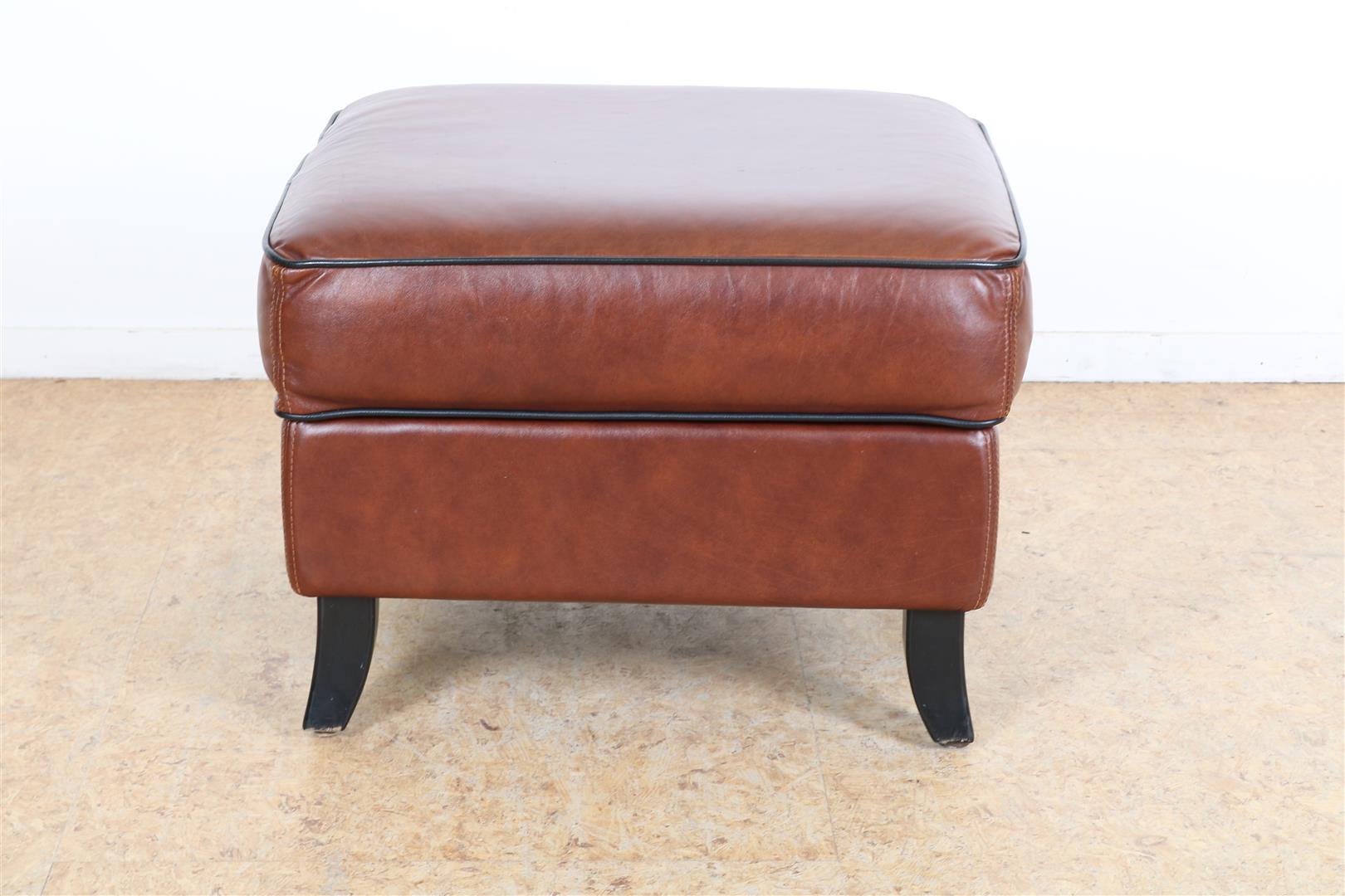 Sheep leather footstool/hooker with black piping on wooden legs, 43 x 62 x 62 cm.