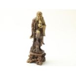 Soapstone sculpture of an immortal with gourd and stick, on pedestal, China, ca. 1900, height 25 cm.