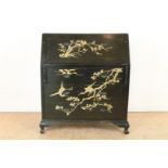 Black lacquer wooden desk with sloping writing flap behind which an interior with compartments on